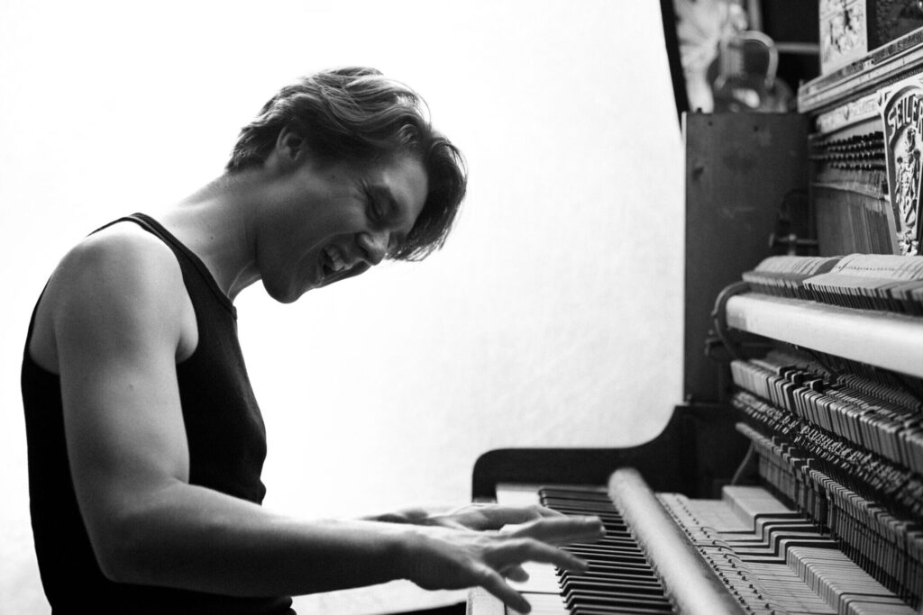 Picture of Sem playing the piano in black and white.