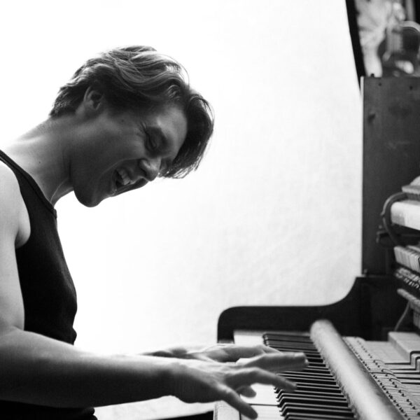 Picture of Sem playing the piano in black and white.